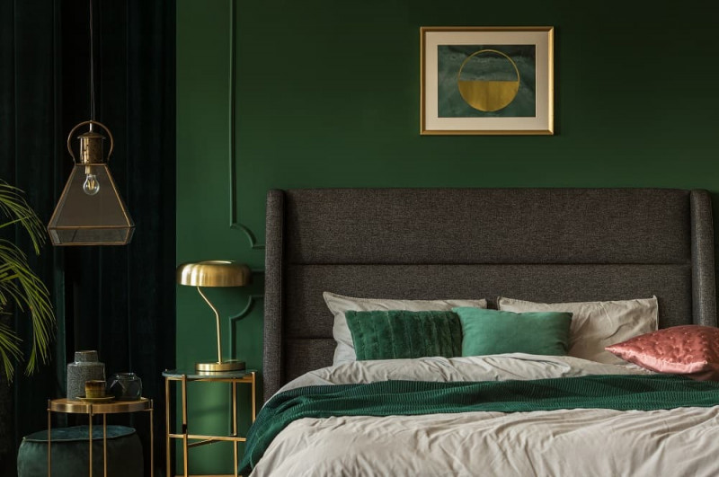 Zielona ściana w sypialni i złote dodatki